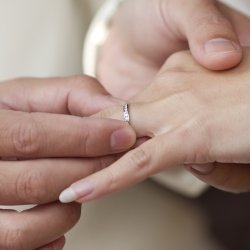 Couple exchanging engagement rings