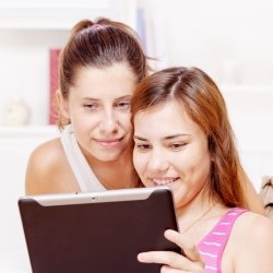 Two girls looking at iPad or tablet PC